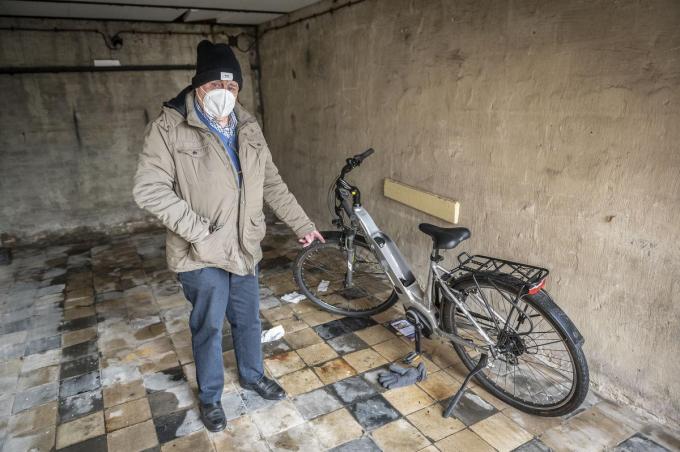 Jos Bogaerts in zijn garage bij zijn elektrische fiets waar de batterij gestolen werd.© Stefaan Beel