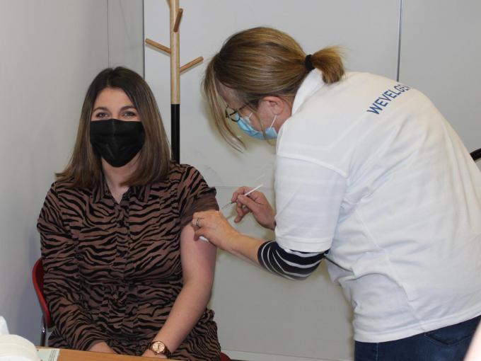 De 23-jarige Saida Qnioun uit Wevelgem kreeg als eerste haar prikje in het vaccinatiecentrum van de Porseleinhallen in Wevelgem.©wilfried Ossieur WO