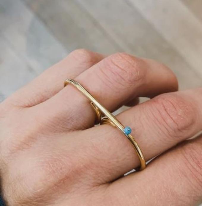 Dubbele gouden ring met subtiel blauw steentje