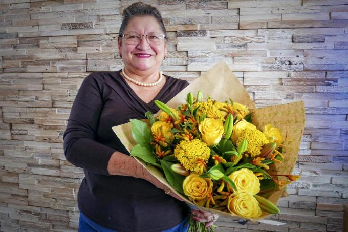 Moederkloek Rosa Salazar, een volbloed Ecuadoriaanse, is maar wat blij met de ruiker bloemen. (foto CLL)