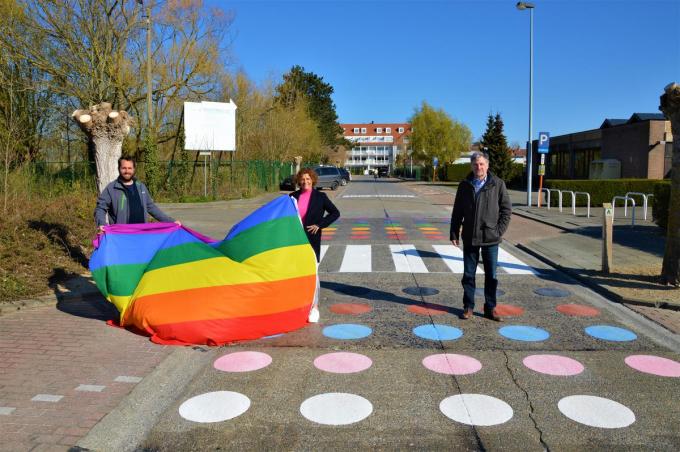 Schepen Mathieu Delbarge, schepen Marleen De Soete en burgemeester Wilfried Vandaele stellen trots het regenboogzebrapad voor.© WK