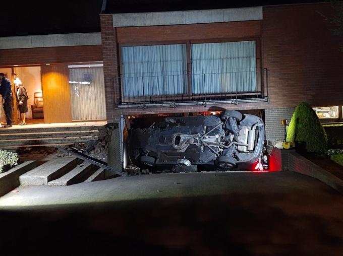 De auto blokkeerde de volledige garagepoort na het ongeval. Twee inzittenden moesten bevrijd worden.© Bert Feys