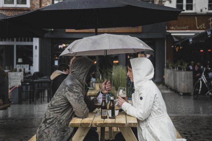 Schuilen onder een kleine paraplu voor de felle regen.© Olaf Verhaeghe