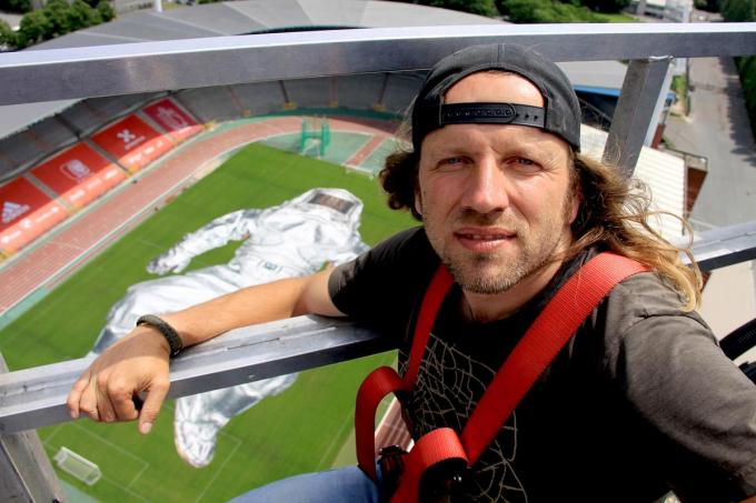 Wim Tellier in de hoogtewerker op 90 meter hoogte met zicht op zijn foto.© PADI/Daniël
