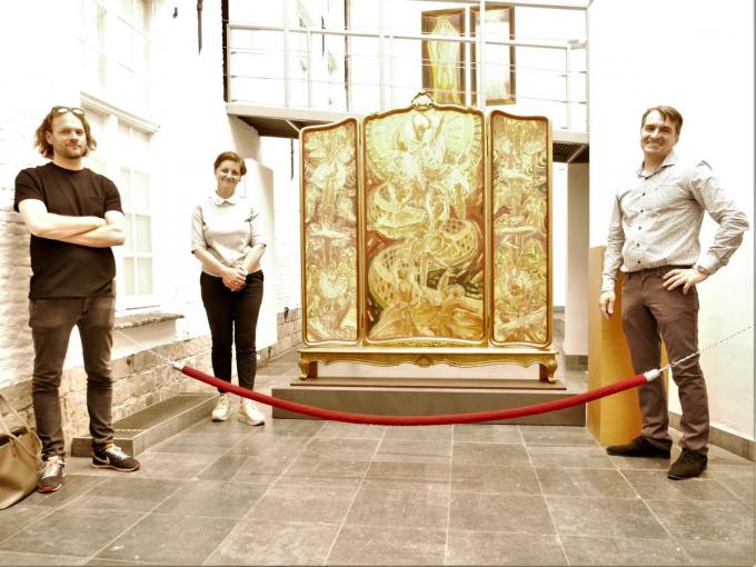 Curator Chiel Vandenberghe, cultuurschepen Griet Vanryckegem en kunstenaarszoon Dominique Crombé poseren bij het bombastische drieluik ‘Ode aan de vreugde’, het laatste grote werk van Luc-Peter Crombé. (foto CB)