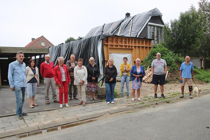 Het buurtcomité dat zich inzet om het getroffen gezin te helpen, onder impuls van Kris Vanblaere (uiterst links), poseert voor het huis van Claudia Cogghe en Bart D’Hulster dat door brand werd getroffen.© ACK