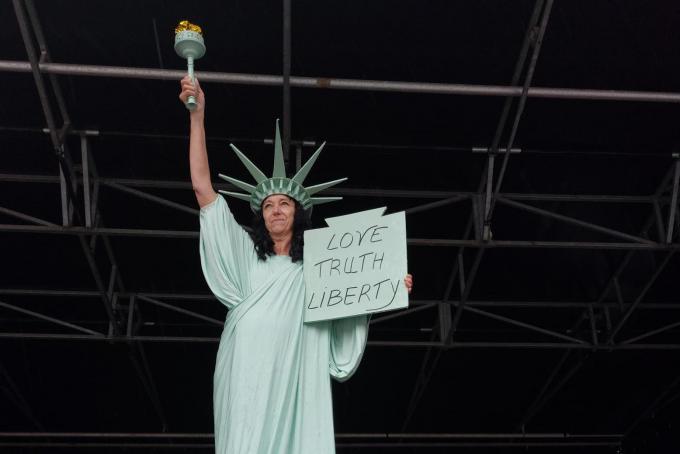 Een vrouw verkleed als vrijheidsbeeld wachtte de betogers op de Markt in Brugge op.