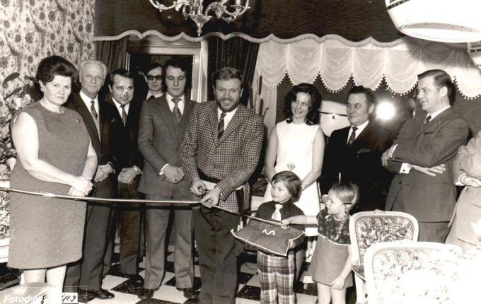 De opening van het salon in 1972, toen vader André de zaak startte. Je herkent André en Nadine links en rechts van toenmalig schepen Lagast. Kleine Steve torst het kussentje.