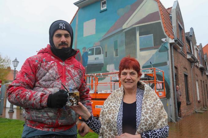 Tamara Derous laat Iñigo Sesma in de druilige regen proeven van haar soep aan het schilderwerk op haar gevel in de Werkzaamheidstraat.