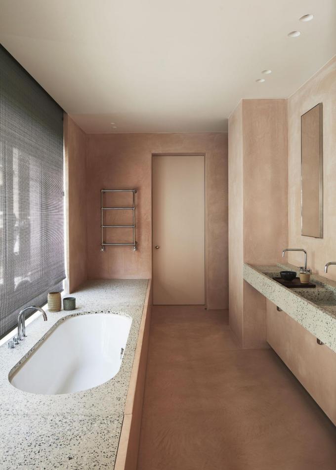 De zussen wilden graag een roze badkamer. Vercruysse combineerde tadelakt in een zachte tint met accenten in terrazzo.