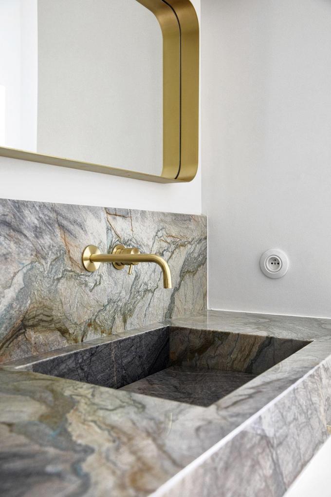 Dans la salle de bains, on retrouve aussi des feuilles de marbre de chez Cromarbo, alliées à des accessoires dorés, de Vervloet et Jules Wabbes notamment.