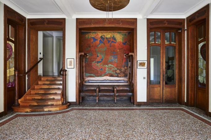 De inkomhal is versierd met een wandtapijt van kunstschilder Emily Fabry, die vaak met Horta samenwerkte. De bank is een ontwerp van Horta.