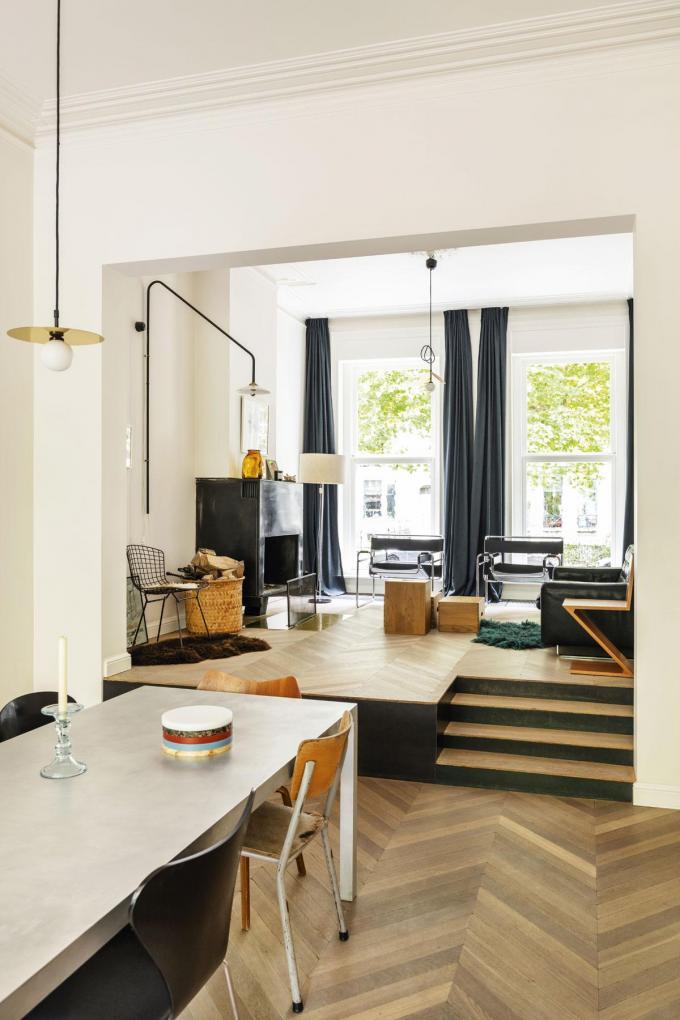 Un salon avec mezzanine accueille du mobilier vintage signé Maarten Van Severen pour la table, Gerrit Rietveld, Arne Jacobsen, Harry Bertoia, Marcel Breuer pour les chaises, Areti pour les luminaires et De Sede pour le canapé.