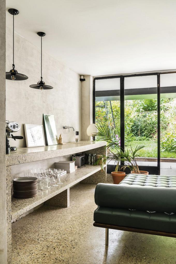 Au sous-sol lumineusement réinterprété en sauna, le jardin s’offre au regard depuis le lit de repos Barcelona de Mies van der Rohe.