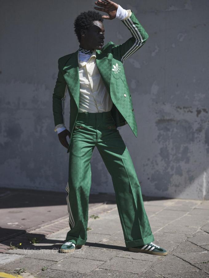 Costume vert et sneakers en daim Gazelle, Gucci x Adidas. Blouse en soie et pull à col roulé à motif jacquard, Prada.