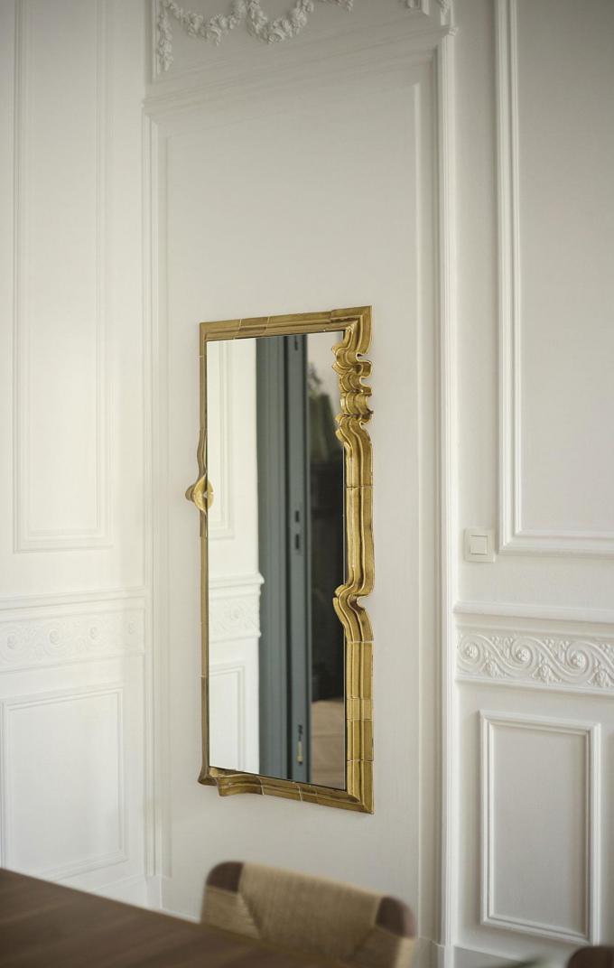 Een spiegel met een keramische lijst, geïnspireerd op het houten lijstwerk in designgalerie Avenue du Roi.