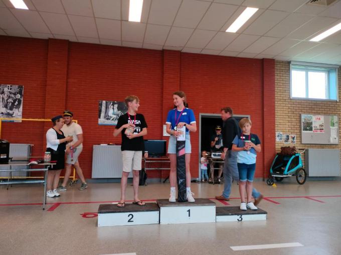 We zien het podium van de verste worp in de categorie 8 tot 13 jaar op het kampioenschap papieren vliegers werpen, met v.l.n.r. Tijl Gekiere, Maud Wittouck en Ethan Deleye.