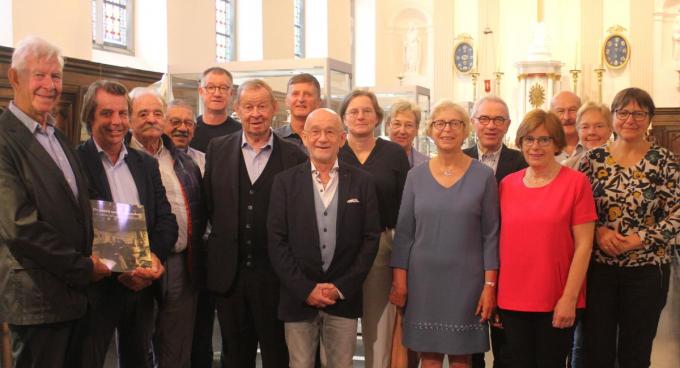 Op de foto zien Luc Adriaen (kleinzoon), Kristof Papin (curator van de tentoonstelling), Ludo Huyghe, Bert Bouve, Patrick Boone (voorzitter), Johan Adriaen (kleinzoon), Filip Coutigny (PR), Daniël Pollet, Isabel Decrock (schatbewaarder), Ingrid Tommelein, Greta Coevoet, Willy Deroo, Sabine Top, Joël Vercruysse, Cecile Gesquiere en Sophie Gruwez (secretaris).