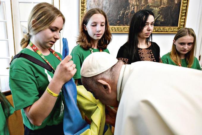 Franciscus kust de Oekraïense vlag tijdens een ontmoeting op de Wereldjongerendagen in Lissabon.