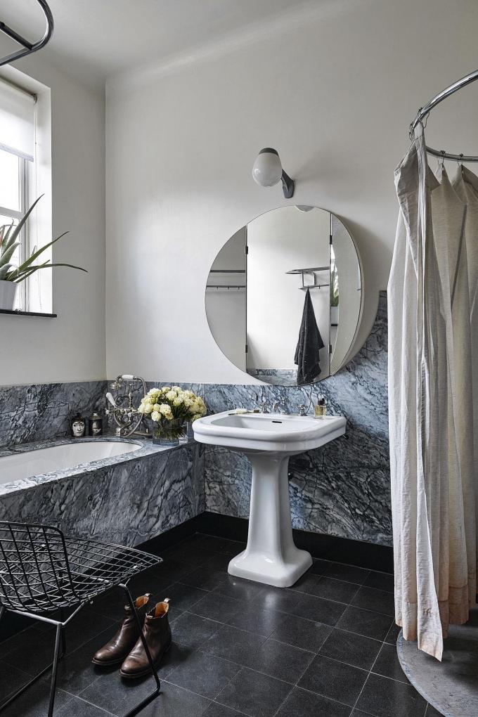 La salle de bains en marbre rénovée par Damian O’Sullivan. On y retrouve la forme ronde dans le miroir.