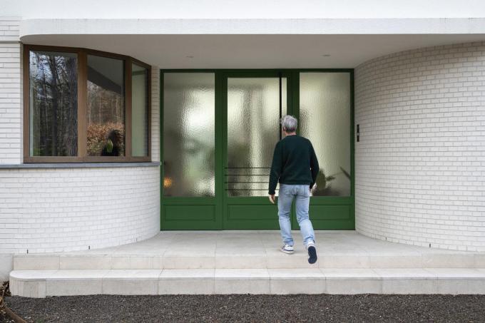 De voordeur en de garagepoort in afrormosia kregen een lik groene verf als knipoog naar het bos en de vroegmoderne architectuur.