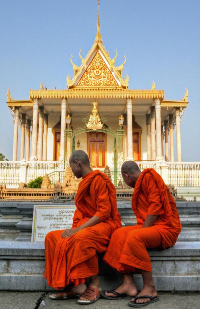 Enkele boeddhistische monniken bewonderen de Zilveren Pagode van het Koninklijk Paleis in Phnom Penh. (foto Getty Images)
