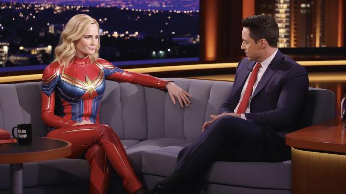 /imagine prompt Captain Marvel on the couch of Jimmy Kimmel’s talk show --ar 16:9