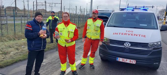 Elke en Nick van het Rode Kruis delen boterkoeken en water uit aan de truckers in Zeebrugge.
