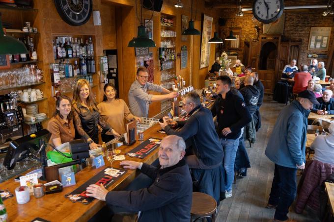 Tom Sintobin presenteert van achter de toog een pint aan zoon Sander. Naast hem enkele dames uit zijn team met Klaartje Maertens, Fleur De Vos en Kamilla Abdulina.