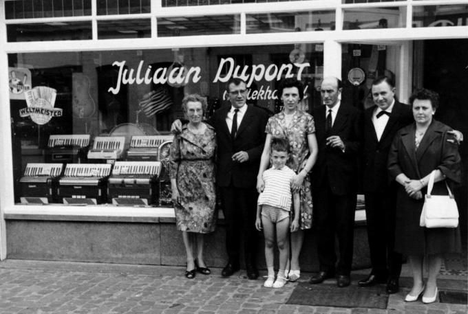 Muziekwinkel Juliaan Dupont, met vooraan de kleine Rudy en van links naar rechts Elodie Couckuyt, de moeder van Juliaan, Aimée Sonneville, boekhouder uit Wevelgem, Magdalena Vanparijs, de vrouw van Juliaan, Juliaan Dupont, Roger Verschelde en echtgenote.