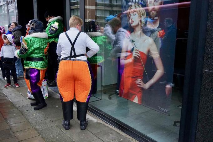 Net voor de start van de carnavalstoet op de eerste zondag van maart. De broek van de mevrouw correspondeert met de jurk van het model in de etalage.