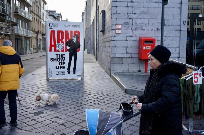 De affiche van Arno titelt ‘De show of life’ en dat is wat er zich ook in dit tafereel afspeelt: het leven van alledag tijdens een marktdag op het Wapenplein.