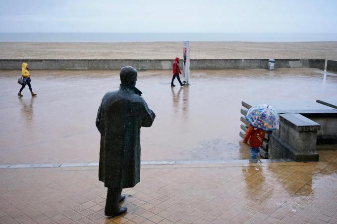 Bij het buitenkomen van de expo van fotograaf Danny Willems over zijn leven met Arno: op deze regenachtige dag zijn de mensen op beeld in perfecte compositie met het Boudewijn-standbeeld.