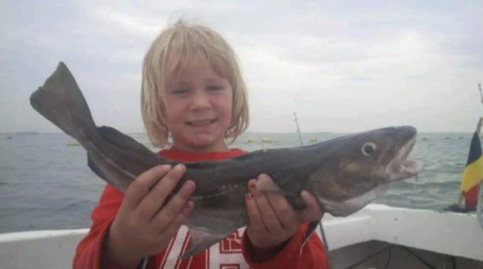 Kato Lowagie als 6-jarige met een kabeljauw op de boot van papa Hans. (foto JTV)