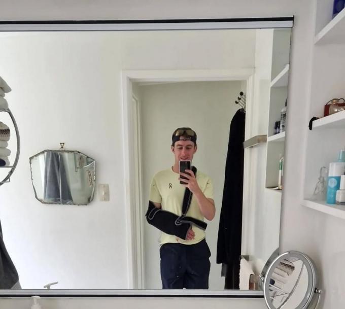 Pacer Kobe neemt een selfie in de spiegel met zijn ingepakte arm om zijn gebroken elleboog te laten herstellen.