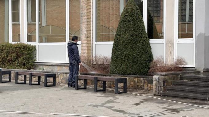 Vrijwilligers spoelen met water alles waar de leerlingen mee in contact kunnen komen.