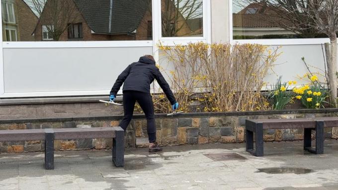 Vrijwilligers spoelen met water alles waar de leerlingen mee in contact kunnen komen.