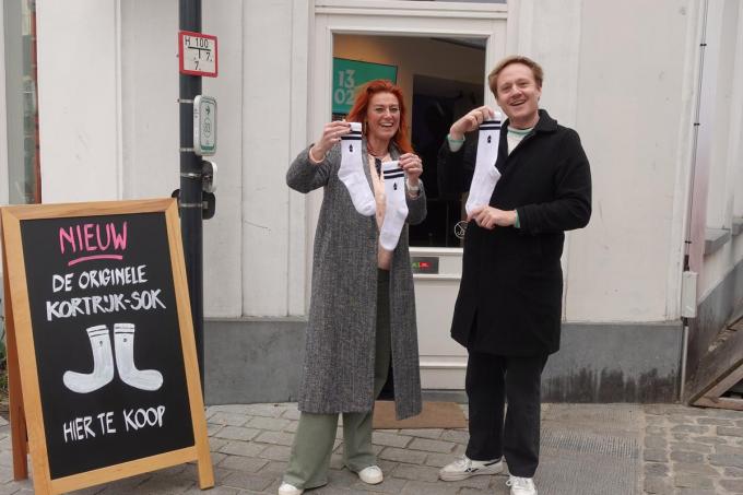 Ruth Vandenberghe en Maxim Veys (schepen van Toerisme) met sokken in de hand aan het toeristisch infopunt aan het Begijnhof.