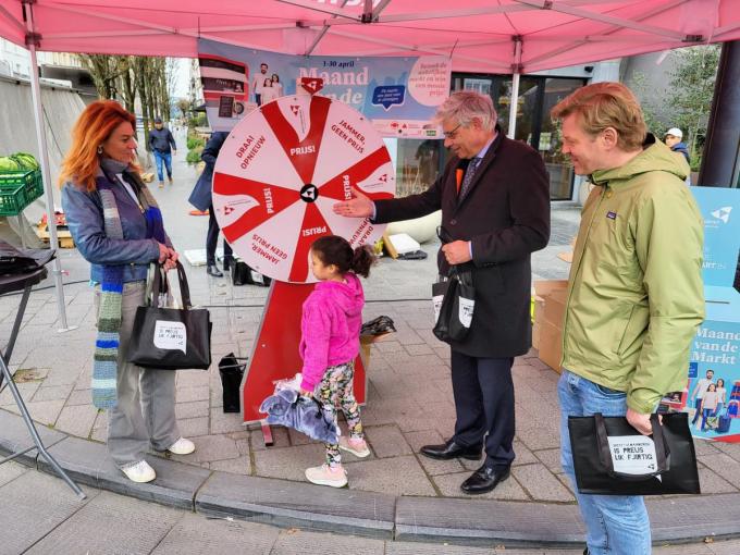 Burgemeester Ruth Vandenberghe, gedeputeerde Jean de Béthune en schepen Wouter Allijns aan de promostand tijdens de maandagmarkt.