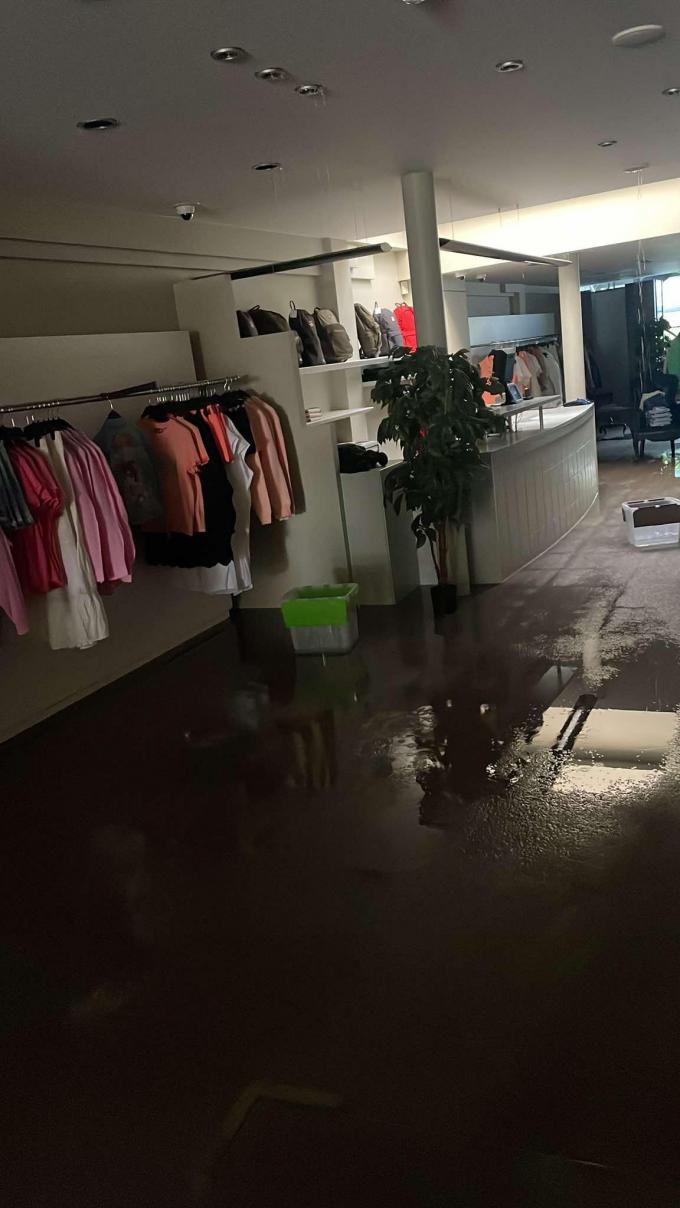 Sommige rekken met kleding - diegenen die onder de spots stonden - kregen vocht te slikken, al bleven de meeste rekken gespaard. Maar het kamerbrede tapijt in de winkel is van voor tot achter compleet doorweekt.