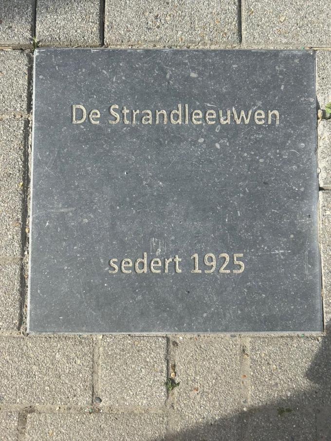 De jubileumtegel aan het museum.