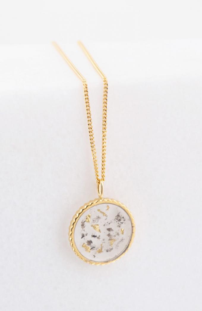 Halsketting met amulet uit 18k goud gevuld met gedroogde moedermelk in hars vervat