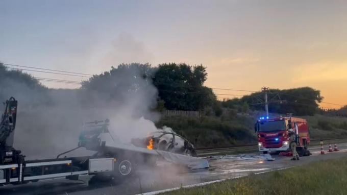 De uitgebrande elektrische Porsche vatte tijdens de takelwerken opnieuw vuur.