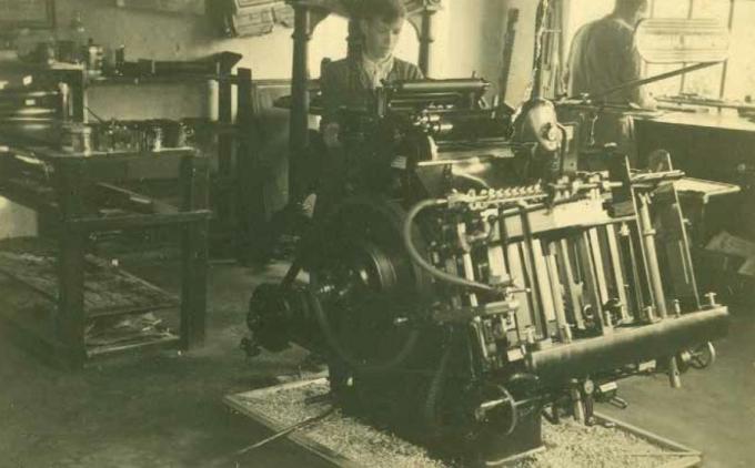 We zien vooraan Guido Schoonaert aan het werk in de drukkerij. Achteraan zien we zijn vader Marcel.