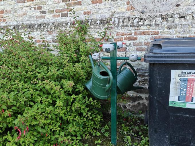 De gieters die ter beschikking gesteld worden op het kerkhof, hangen vast.