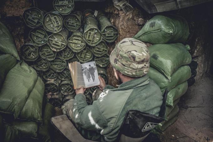 Tussen de gevechten door is het vaak lang wachten. De soldaten verdrijven de tijd met een boek....