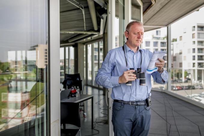 Nicky De Frene aan het werk als commentator op de Gaverbeekhippodroom. De verrekijker, zijn onmisbaar attribuut, in de aanslag.
