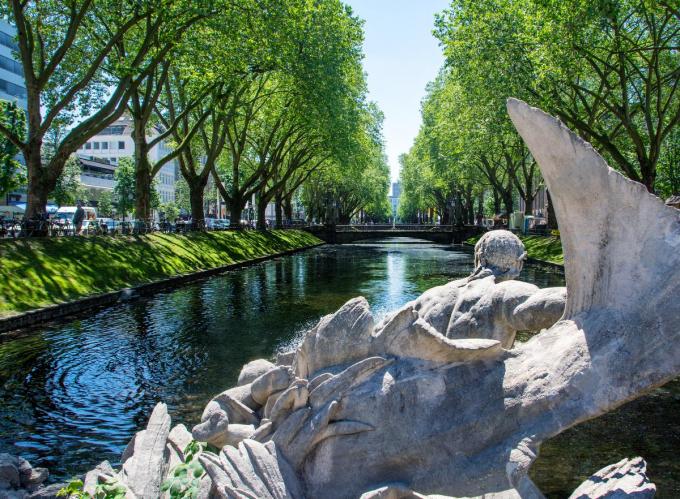 Mét een kanaal omzoomd met bomen: de Königsallee is geen doorsnee winkelstraat. (foto Visit Düsseldorf)