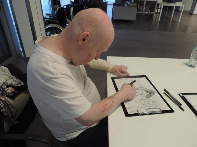 Dominique verdiept zich in een nieuwe tekening, met oog voor elk detail.