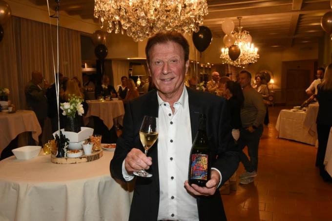 Patrick Vandewattijne met zijn gepersonaliseerde champagnefles in de hand.